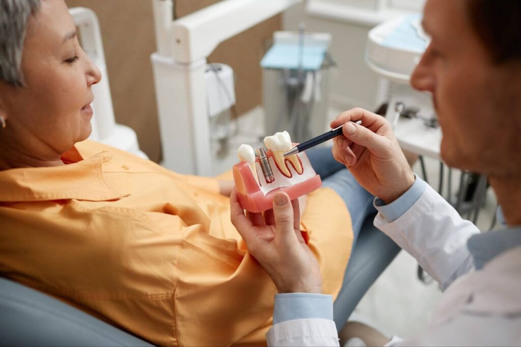 Dentist explaining dentures vs implants to patient